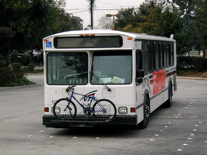 City bus with bicycle on the front.