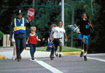 Children crossing the street with a crossing guard