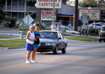 Pedestrians stopped in the middle of a 4-lane road