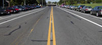 Two-lane road with back-in parking on one side and parallel parking on the other side.