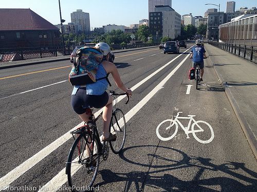 Bicyclists use the new buffered bike lane after crossing the Broadway Bridge.