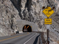 A view of the tunnel approach, showing the warning sign with flashing beacons.