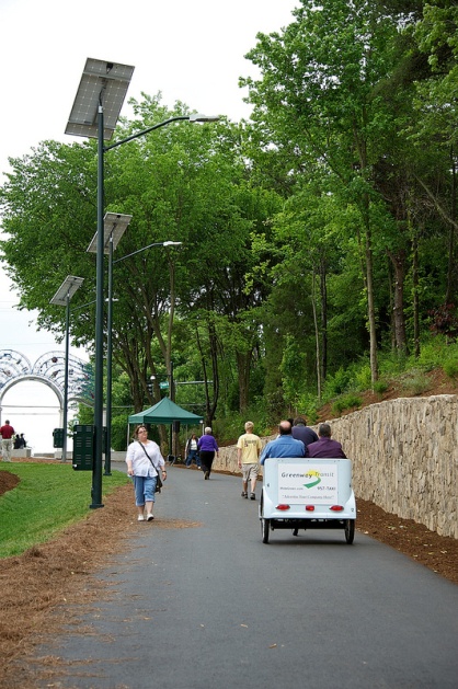 Pedestrians and a pedi-cab using the greenway.